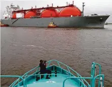  ?? Mark M. Hancock / Beaumont Enterprise file ?? A Coast Guard photograph­er works on the deck of a ship transporti­ng cargo to Cheniere’s Sabine Pass LNG.