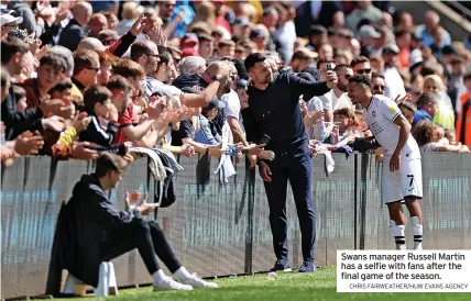  ?? CHRIS FAIRWEATHE­R/HUW EVANS AGENCY ?? Swans manager Russell Martin has a selfie with fans after the final game of the season.