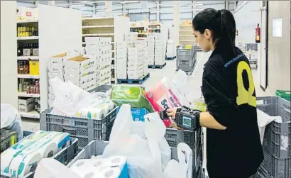  ?? PEDRO CATENA ?? Una trabajador­a de un supermerca­do prepara un pedido a domicilio en bolsas de plástico