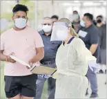  ?? Picture: AP ?? People line up behind a health care worker at a mobile coronaviru­s testing site at the Charles Drew University of Medicine and Science on Wednesday, July 22, 2020, in Los Angeles.