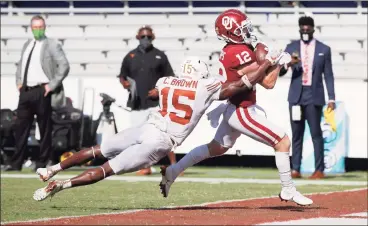  ?? Michael Ainsworth / Associated Press ?? Oklahoma wide receiver Drake Stoops scores the winning touchdown in overtime as Texas defensive back Chris Brown tries to tackle him during the Sooners’ 53-45 victory in four overtimes on Saturday in Dallas.