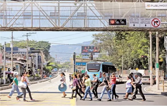  ??  ?? Riesgo. Muchos peatones optan por cruzar la calzada y no utilizar las pasarelas, por lo que la Policía de Tránsito lo considera como una inadecuada cultura vial.