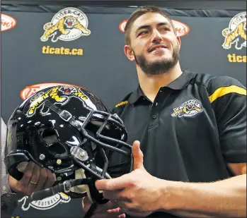  ?? DAVE ABEL/TORONTO SUN ?? Veteran defensive lineman John Chick poses with a Tiger-Cats helmet after joining Hamilton in 2016. He was traded to the Eskimos yesterday for a second-round draft pick next year.