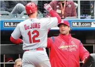 ?? Kathy Willens/The Associated Press ?? ■ St. Louis Cardinals manager Mike Matheny, right, congratula­tes St. Louis Cardinals' Paul DeJong (12) after DeJong hit his second home run of the day during the eighth inning Sunday against the New York Mets in New York.