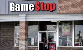  ?? Photograph: Nam Y Huh/AP ?? A woman wears a face mask as she walks past a GameStop store in Des Plaines, Illinois, US.