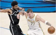  ?? TOM FOX THE DALLAS MORNING NEWS FILE PHOTO ?? Mavericks guard Luka Doncic forces his way past Brooklyn Nets guard Kyrie Irving at the American Airlines Center in Dallas in May 2021. Now the two are teammates.