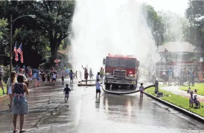  ??  ?? Firefighte­rs from Memphis Fire Station 17 spray water for the crowd at the end of the 70th annual High Point Terrace Independen­ce Day parade on Thursday. PHOTOS BY BRAD VEST/THE COMMERCIAL APPEAL