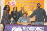  ?? STAFF PHOTO BY MICHAEL REID ?? McDonough High School senior wide receiver Dervonn Holton signs his letter of intent Wednesday to attend Clarion University (Pa.) with grandmothe­r Michelle Valentine, left, brother Navarro O’Brien, mother Javonna O’Brien, grandfathe­r Larry Holton,...