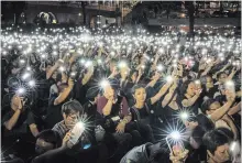  ?? CHRIS MCGRATH GETTY IMAGES ?? Hong Kong women wave their cellphones during a “mums protest” Friday to support protesters who wreaked havoc in the legislatur­e.