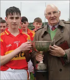  ??  ?? James Murphy, the Horeswood captain, is presented with the cup by Brendan Furlong of People Newspapers (sponsors).