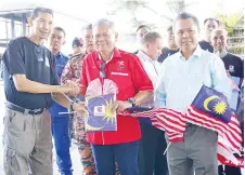  ??  ?? MUIS menerima Jalur Gemilang selepas selesai merasmikan pelepasan pertama kembara daripada Kaya, Pegawai Penerangan Bahagian Tawau.