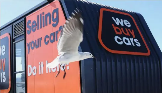  ?? ?? ▲A seagull flies past a second-hand vehicle trader WeBuyCars Buying Pod in Cape Town, South Africa.