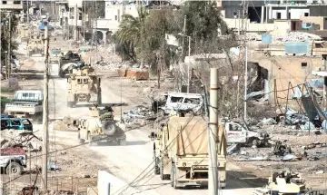  ??  ?? Vehicles belonging to the US-led coalition drive down a street in the frontline Syrian village of Baghuz. — AFP