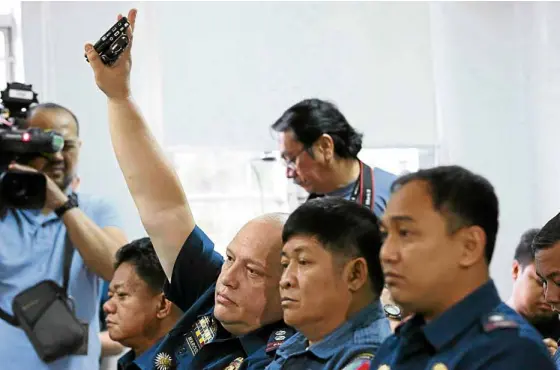  ?? —INQUIRER PHOTO ?? Supt. Marvin Marcos (hand raised) and other police officers charged with killing Albuera Mayor Rolando Espinosa Sr. at a preliminar­y investigat­ion hearing in the Department of Justice last December