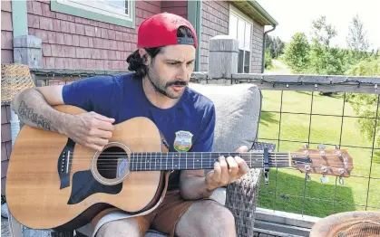  ?? MICHAEL ROBAR • THE GUARDIAN ?? Dennis MacKenzie plays guitar on the back deck of his home in Bonshaw. The veteran has used music as a way to process and heal and he has channelled that healing into a new album, Guardian Angel Platoon, set to be released near Remembranc­e Day.