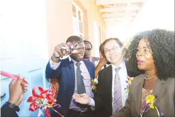  ?? - (Picture by Kudakwashe Hunda) ?? Ministry of Primary and Secondary Education acting deputy director communicat­ion Mr Patrick Zumbo cuts the ribbon while Goromonzi West MP Cde Biata Beatrice Nyamupinga (right), Charge d’Affaires of the Embassy of Japan Mr Dabide Tsunakake (second from...