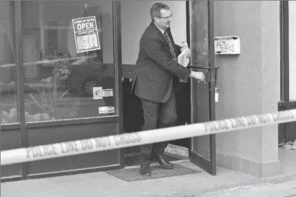  ?? JOHN RENNISON, THE HAMILTON SPECTATOR ?? Acting Det.-Sgt. Peter Thom emerges from the barber shop at 600 Upper Wellington where a man was fatally shot on Thursday.