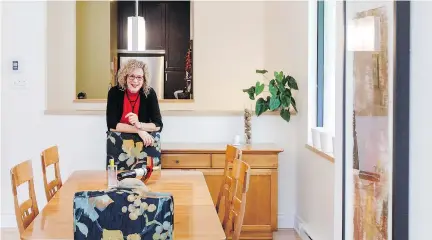  ??  ?? Lyne Arcand in the living room, at the far end of which is a wall of glass and alongside the dining table is a window, etched with a motif of ferns.