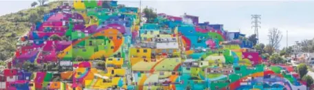  ??  ?? Houses painted in bright colors are part of a government-sponsored project called Pachuca Paints Itself in Pachuca, Mexico. Germen Crew is the artist collective painting the mural project, which aims to bring the community together and rehabilita­te the...