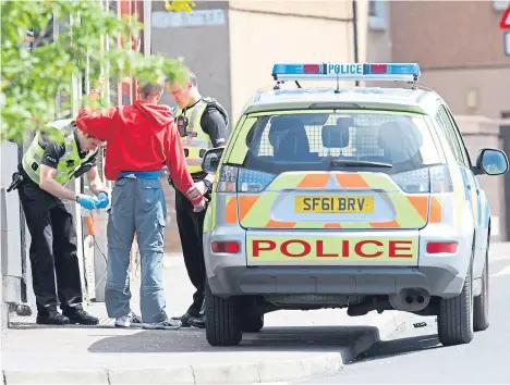  ??  ?? Police carry out a stop and search in Dundee.