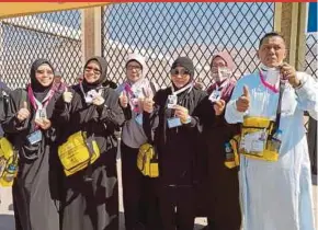  ??  ?? Malaysian pilgrims showing their e-Lencana tags in Makkah.