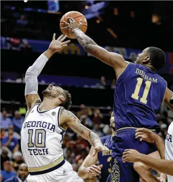  ??  ?? Notre Dame’s Juwan Durham blocks a shot by Georgia Tech’s Jose Alvarado during the first half of their Atlantic Coast Conference tournament game in Charlotte, N.C., on Tuesday. The Jackets, known for their defense during the regular season, yielded 52 points in the first half.