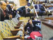  ?? ANDREW HARNIK AP ?? People shelter in the House gallery as protesters try to break into the House chamber on Wednesday.