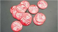  ??  ?? These pins being sold at Nationals Park deliver the one message Democrats and Republican­s can agree on as Washington prepared to host its first World Series game in 86 years on Friday night.