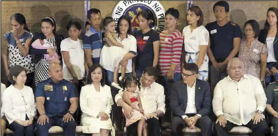  ??  ?? President Duterte joins families of slain soldiers and police in the Marawi conflict during the Go Negosyo Kapatid financial assistance turnover ceremony at Malacañang yesterday. Also in photo are business leader Teresita Sy-Coson, PNP chief Director...