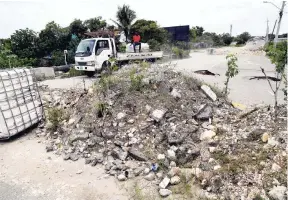  ?? PHOTO EDITOR NORMAN GRINDLEY/CHIEF ?? Motorists continue to risk using this collapsed bridge at the intersecti­on of Dyke Road and Passage Fort Drive in Portmore, St Catherine, that was blocked off by the National Works Agency last year.