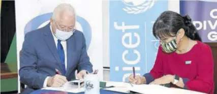  ?? (Photo: JIS) ?? Justice Minister Delroy Chuck signs a $10-million memorandum of understand­ing with UNICEF Country Representa­tive Mariko Kagoshima on December 9 at the ministry’s head office at 61 Constant Spring Road in St Andrew.