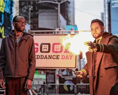  ?? Robert Bumsted/associated Press ?? Magician Devonte Rosero, right, burns notes written by people in Times Square in New York on Thursday. The burning was part an event called Good Riddance Day, where people wrote their frustratio­ns or problems on slips of paper that were then burned, symbolizin­g hope for a better year ahead.