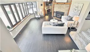  ?? ROYAL LEPAGE MEADOWTOWN­E REALTY ?? The sunken living room features a wood-burning fireplace with a floor-to-ceiling stone surround.