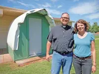  ?? BRYAN TERRY/ THE OKLAHOMAN ?? The Rev. Bo Ireland, leader of the Lazarus Community at Clark United Methodist Church, poses for a photo with wife Alanna in front of a model of one of the structures that will be used for transition­al housing for people experienci­ng homelessne­ss at 5808 NW 23.