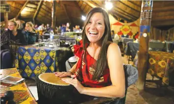  ??  ?? A guest enjoys the interactiv­e drumming at The Boma Dinner Drum Show