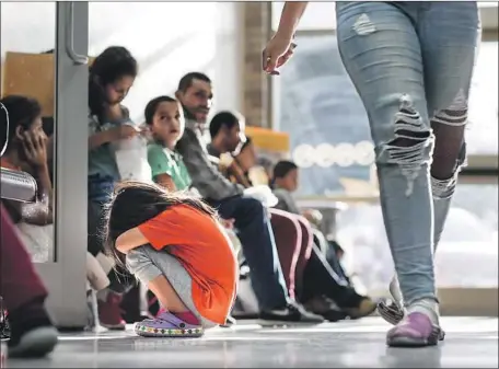  ?? Robert Gauthier Los Angeles Times ?? MIGRANTS wait at a bus terminal in McAllen, Texas, after being processed and released from detention. This week, a federal judge in San Diego ordered an immediate halt to the practice of separating immigrant children from their parents at the U.S.-Mexico border.