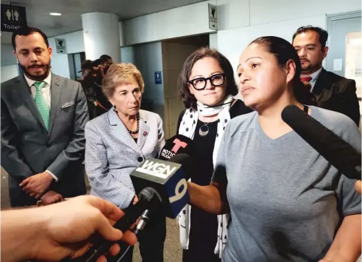  ?? MANNY RAMOS/SUN-TIMES ?? Silvia, who declined to provide her last name, at O’Hare Airport after picking up her three daughters. They had been detained by Customs and Border Protection officials about 12 hours, supporters of the family said. U.S. Rep. Jan Schakowsky (second from left) had just landed as the situation was unfolding.