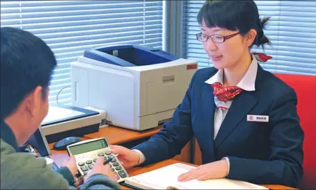  ?? SHA LANG / FOR CHINA DAILY ?? An employee from the Bank of China introduces financial services to a client in Zhengzhou, Henan province.