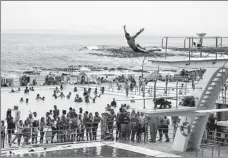  ?? LYU TIANRAN / XINHUA ?? People relax at a pool in Cape Town on Sunday. South Africa has avoided another lockdown despite a surge in COVID-19 infections due to the Omicron variant.