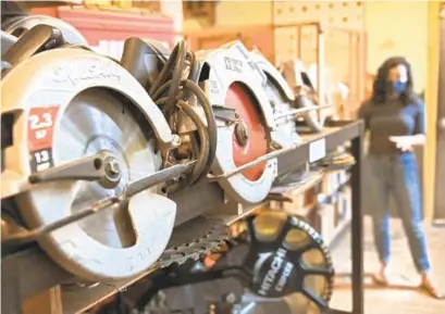  ?? KARL MERTON FERRON/BALTIMORE SUN PHOTOS ?? Rotary saws are stored Tuesday in front of Lynn McCann, director of developmen­t in the Station North Tool Library in Area 405, which is now for sale.