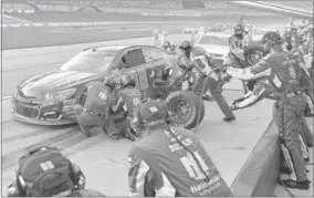  ?? AP/TIMOTHY D. EASLEY ?? Dale Earnhardt Jr. makes a pit stop for more tires at Kentucky Speedway. Goodyear brought the hardest tires it could make to keep them from blistering on Kentucky’s new asphalt surface.