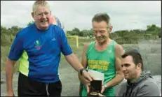  ??  ?? LEFT: Tiger receives his 100th marathon medal in the company of his son Paul - his inspiratio­n for getting involved in marathon running - and friend Ken Beggs.