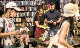  ?? Mel Melcon Los Angeles Times ?? AMANDA LIM and Garvin Tam of San Francisco shop at the Last Bookstore in downtown L.A. last week after the plan to reinstate a mask mandate was dropped.