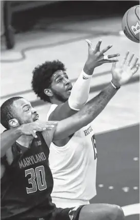  ?? ANDREW MILLS/AP ?? Maryland forward Galin Smith and Rutgers center Myles Johnson battle for the ball during the first half of the Terps’ victory over the Scarlet Knights on Sunday in Piscataway, N.J.