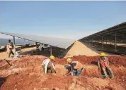  ?? Associated Press file photo ?? Laborers work at the Pavagada Solar Park north of Bangalore, India, in 2018.