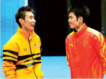  ??  ?? Lin Dan (right) talks to Lee Chong Wei of Malaysia as they wait at the podium during an award ceremony at the 16th Asian Games in Guangzhou, China.