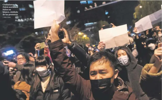  ?? // REUTERS ?? Ciudadanos de Pekín sostienen folios en blanco, símbolo de las protestas