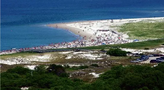  ?? CHITOSE SUZUKI/ASSOCIATED PRESS ?? Crane Beach in Ipswich as seen from the Great House in the Crane Estate on a busy summer day. The Massachuse­tts Office of Travel & Tourism recently dispensed six $1 million grants to boost offseason tourism throughout the state.