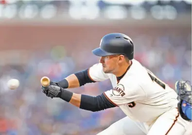  ?? Scott Strazzante / The Chronicle 2019 ?? Joe Panik, then with the Giants, bunts for a single against the Los Angeles Dodgers in the first inning of a game at Oracle Park on April 29, 2019. With baseball’s new rule to put a runner at second base at the start of every halfinning after the ninth, the lost art of the bunt should become a critical skill as teams seek to push that run across the plate.