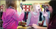  ?? NWA Democrat-Gazette/CHARLIE KAIJO ?? Emily Wilson, 4 (center right), makes a face as Pre-K teacher Laura Thompson (right) holds up a magnifying glass at the Helen R. Walton Children’s Enrichment Center in Bentonvill­e.